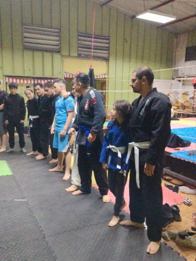 Alumnos de jiu-jitsu en fila durante la ceremonia de ascenso de grados
