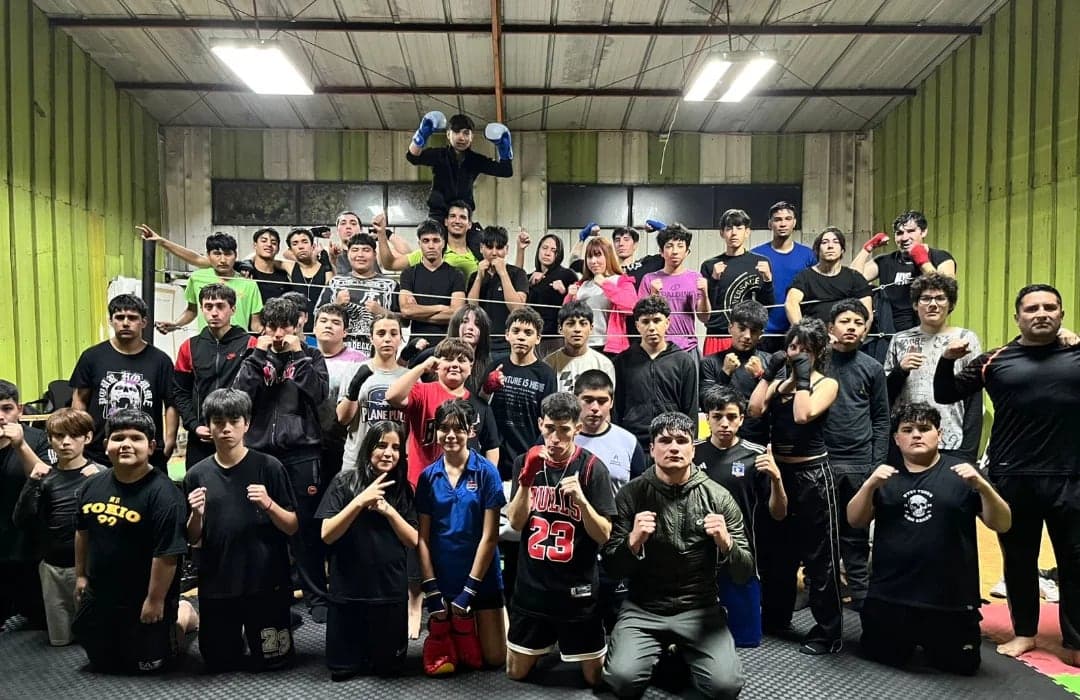 Foto grupal de todo el equipo del club dentro del gimnasio, con los puños en guardia