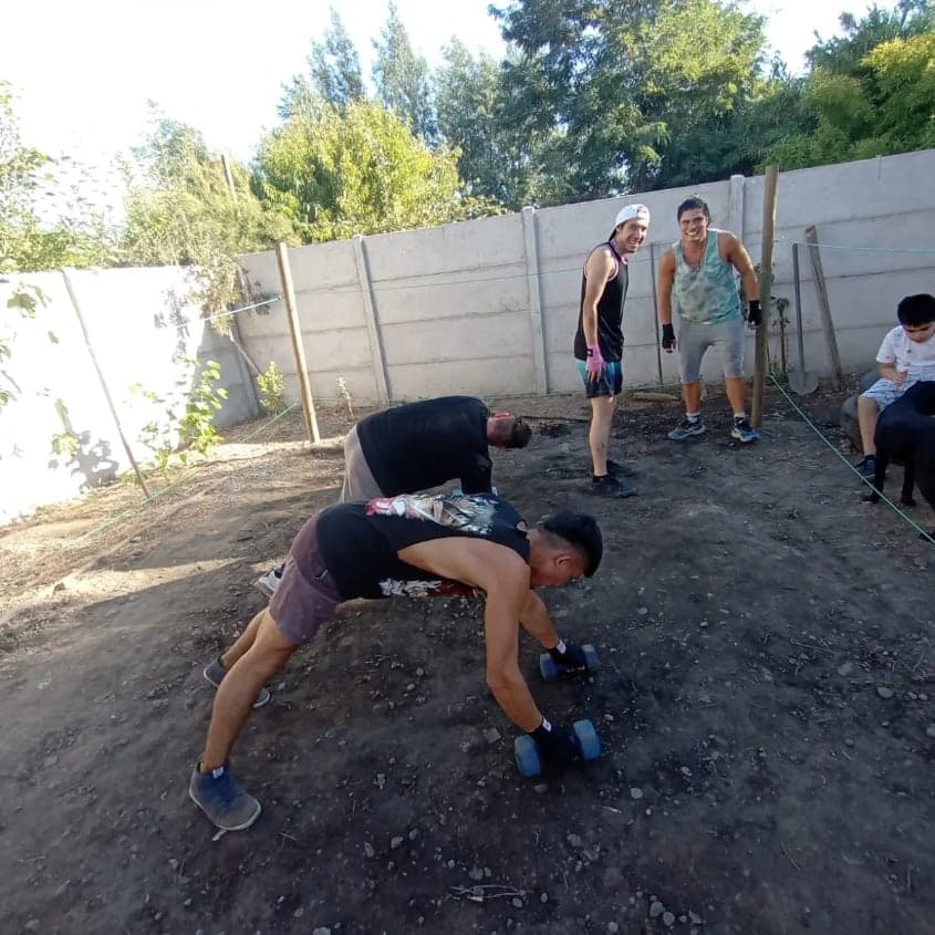 Boxeadores haciendo flexiones sobre la tierra del patio
