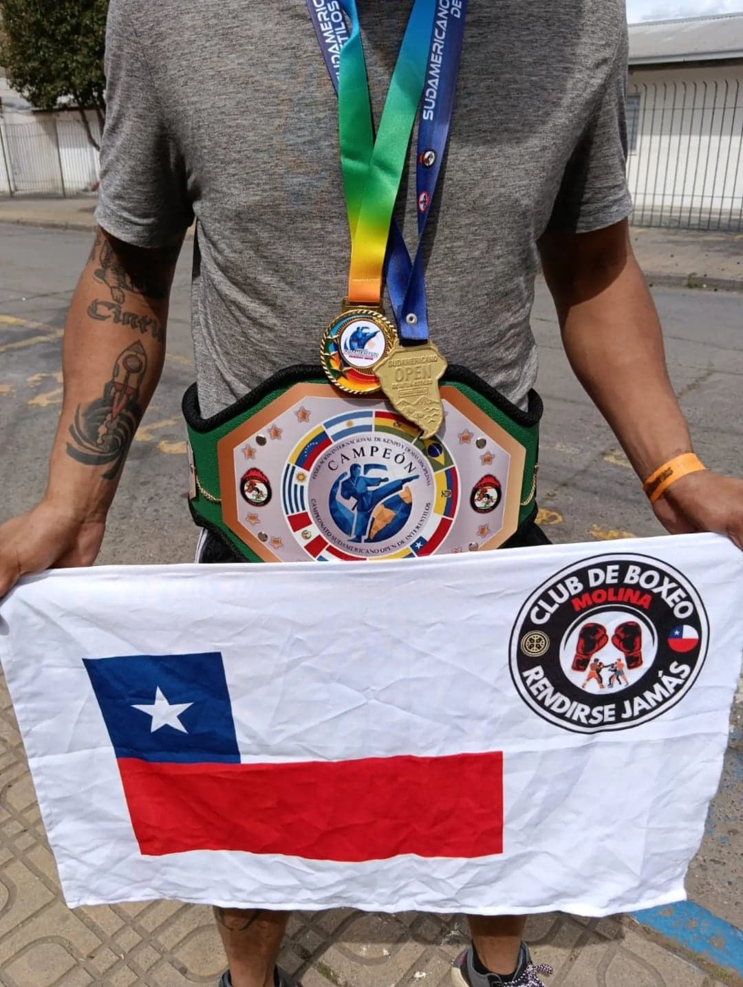 Medalla, cinturón de campeón y bandera de Chile con el escudo del club